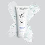 A bottle of exfoliating cleanser on top of a white x with small green dots