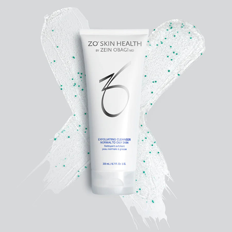 A bottle of exfoliating cleanser on top of a white x with small green dots